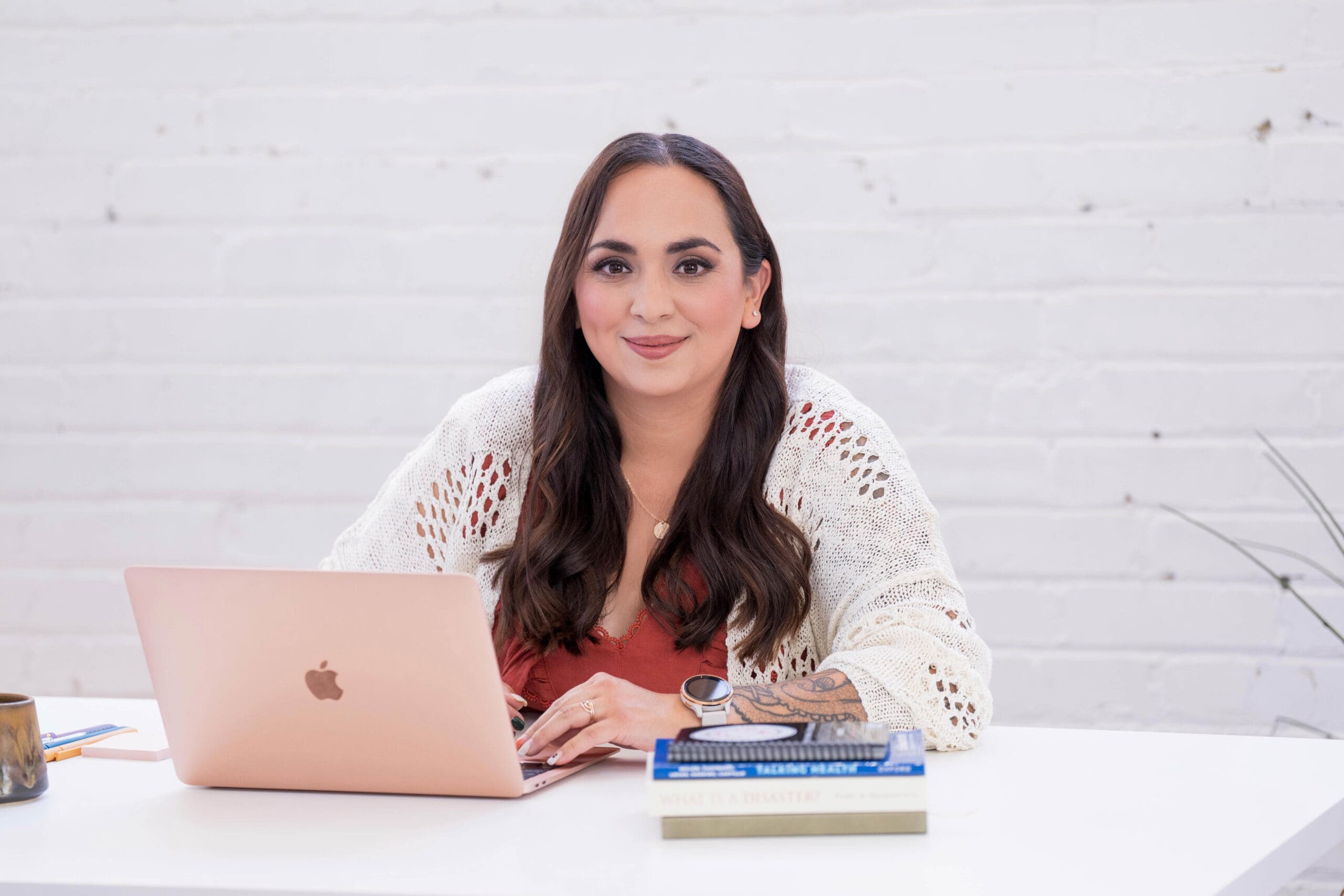 Steph sitting at her laptop smiling at the camera